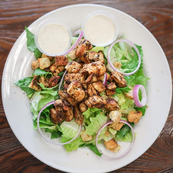 Hobo's grilled chicken salad with lettuce, red onion, croutons, and two cups of dressing.