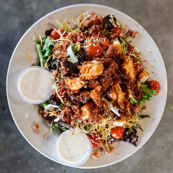 Hobo's American salad with chicken, bacon, tomatoes, cheese, and two cups of dressing.