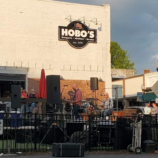 Hobo's restaurant with a band performing live music on an outdoor stage.