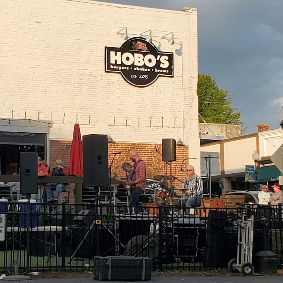 Hobo's restaurant with a band performing live music on an outdoor stage.