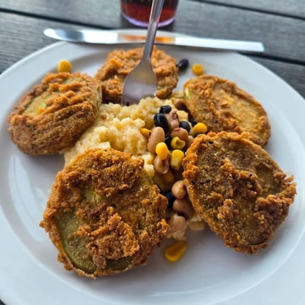 Fried green tomatoes with grits, black-eyed peas, and corn on a white plate at Hobo's.