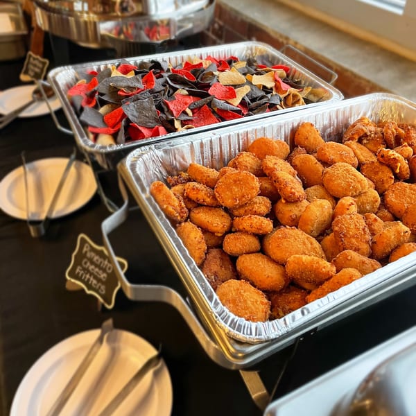 Two buffet trays of food, one with colorful tortilla chips and the other with golden-brown pimento cheese fritters.