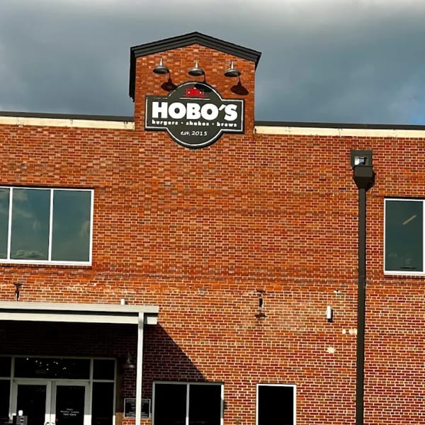 Hobo's restaurant exterior, a brick building with a prominent black and white sign under a dark sky.
